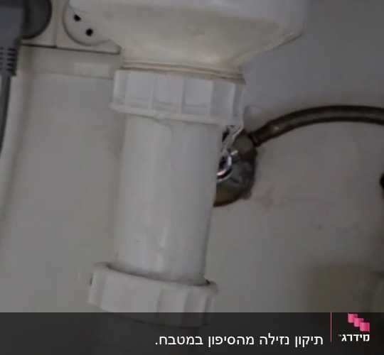 צינור פלסטיק לבן עם חיבורי ברגים מתחת לכיור